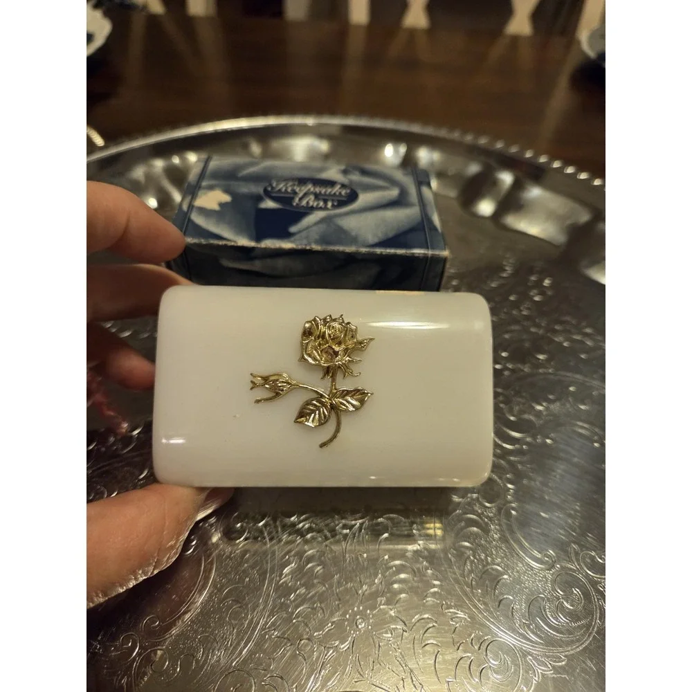 vintage white hinged trinket box features a polished finish with a delicate,...